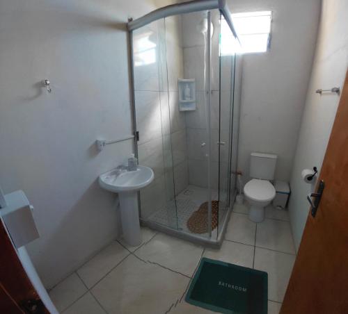 a bathroom with a shower and a sink and a toilet at Pousada do Coqueiro in São Gabriel