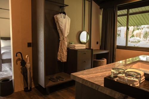 a bathroom with a robe hanging on a wall at Spring River Cisarua in Paragajen