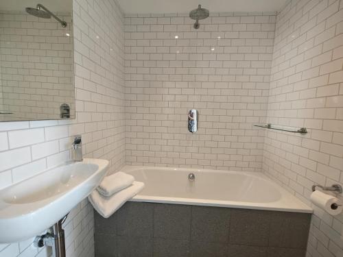 a white bathroom with a tub and a sink at 2 Bed in Craster oc-c25099 in Craster