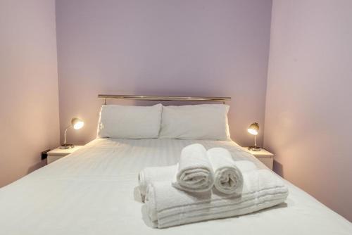a bedroom with a white bed with towels on it at 1 Bed in Tenby oc-w28984 in Tenby