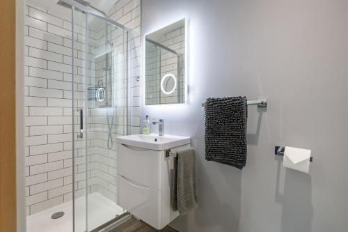 a white bathroom with a sink and a shower at 4 Bed in Saham Toney oc-o30348 in Saham Toney