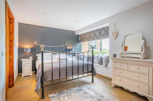 a bedroom with a bed and a dresser and a mirror at 1 Bed in Crakehall oc-o30357 in Crakehall