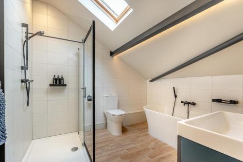 a bathroom with a shower and a tub and a sink at 4 Bed in Ewhurst Green oc-w31032 in Hurst Green