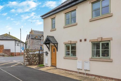 a white house with a wooden door on a street at 3 Bed in Watchet oc-c29959 in Watchet