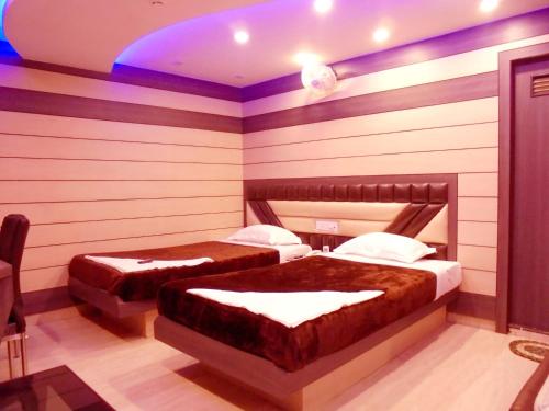 two beds in a room with striped walls at Hotel Great Western in Kolkata