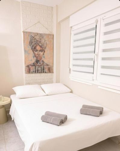 a white bedroom with two towels on a bed at Studio Ocean in Paralia Dionysiou