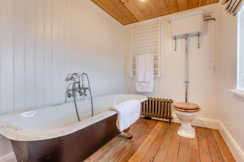 a bathroom with a bath tub and a toilet at 2 Bed in Ardgay oc-w30780 in Achnahanat