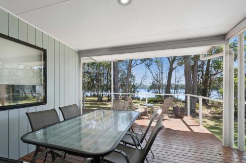 a dining room with a table and chairs on a deck at Ingenia Holidays Lake Conjola in Conjola