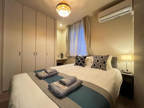 a bedroom with a large bed with towels on it at nestay apartment tokyo sumida in Tokyo
