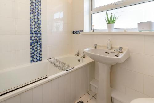 a white bathroom with a sink and a bath tub and a sink at 2 Bed in Oxwich oc-l31089 in Oxwich