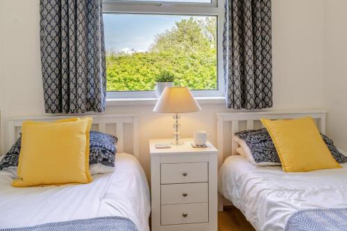 two beds in a room with a window at 2 Bed in Oxwich oc-l31089 in Oxwich