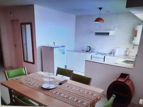 a kitchen with a table and chairs and a kitchen with a table at Complejo Tres Arroyos in Tres Arroyos