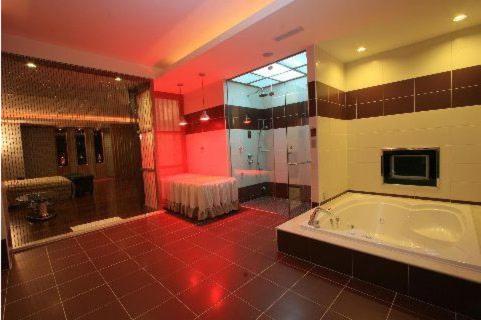 a large bathroom with a tub and a shower at Lisa Motel in Kaohsiung
