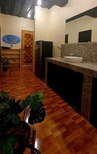 a kitchen with a counter top and a refrigerator at TAGBALAYON Lodging House in Siquijor