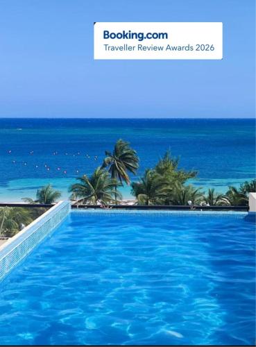 a swimming pool with a view of the ocean at Modern 1 bedroom suite by beach Great location! in Puerto Morelos