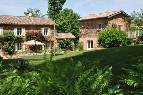 une ancienne maison en pierre avec une grande cour dans l'établissement Chambre d'hôtes Puech Noly, à Mont-Roc