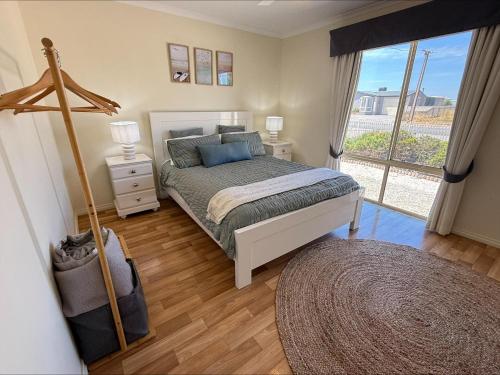 a bedroom with a bed and a large window at Sea Change Coobowie in Coobowie