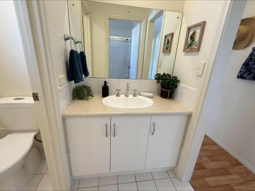 a bathroom with a sink and a toilet and a mirror at Sea Change Coobowie in Coobowie