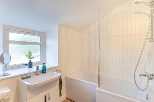 a white bathroom with a sink and a shower at 3 Bed in Crickhowell oc-r32122 in Crickhowell