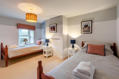 a bedroom with two beds and a window at 3 Bed in Caldbeck oc-h30704 in Caldbeck