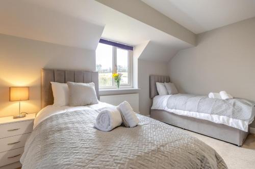 a white bedroom with two beds and a window at 4 Bed in Caistor oc-t30831 in Caistor