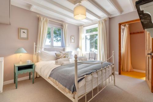 a bedroom with a bed and a table and windows at 2 Bed in Kettlestone oc-t32268 in Little Snoring
