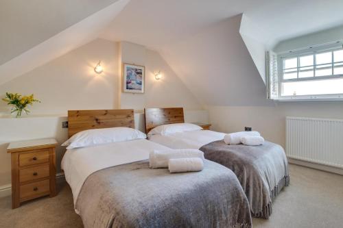 a attic bedroom with two beds and a window at 2 Bed in Aberaeron oc-bow173 in Aberaeron