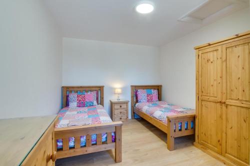 two twin beds in a room with wooden cabinets at 2 Bed in Gower oc-hh487 in Penclawdd