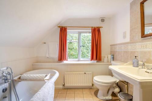 a bathroom with a tub and a toilet and a sink at 4 Bed in Arne oc-wy343 in Arne