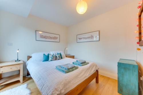 a bedroom with a bed with blue pillows on it at 1 Bed in Aldeburgh oc-sld in Aldeburgh
