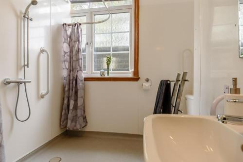a bathroom with a tub and a window and a sink at 1 Bed in Sizewell oc-gdnf in Sizewell