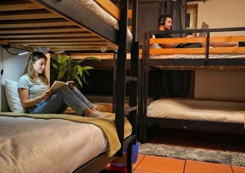 two girls sitting on bunk beds reading a book at Hostel Cangas Backpackers in Cangas de Morrazo