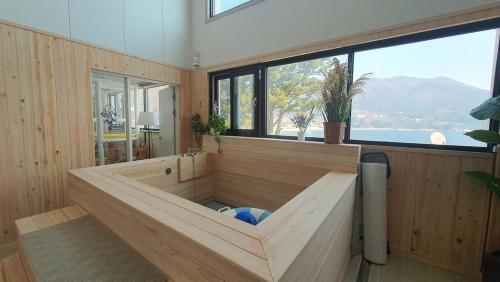 a large tub in a room with windows at Geoje Theview Kids Poolvilla in Geoje