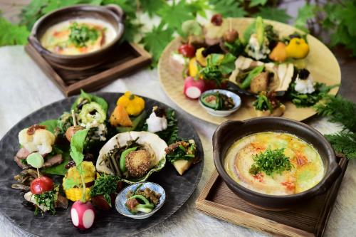 a table with plates of food and bowls of food at Shibu Tatunokan in Chino