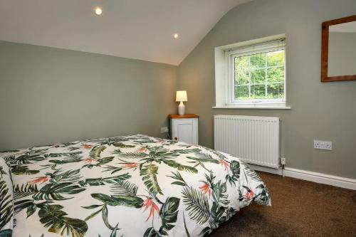 a bedroom with a bed with a floral bedspread at 3 Bed in Abersoch oc-egrynb in Abersoch