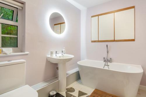 a white bathroom with a tub and a sink at 2 Bed in Stoke Abbott oc-r31870 in Stoke Abbott