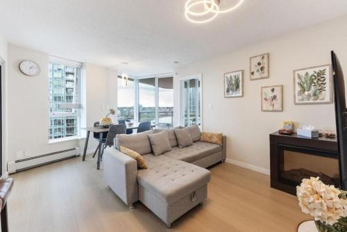 a living room with a couch and a fireplace at BC Place & Rogers Arena Downtown Modern Condo in Vancouver