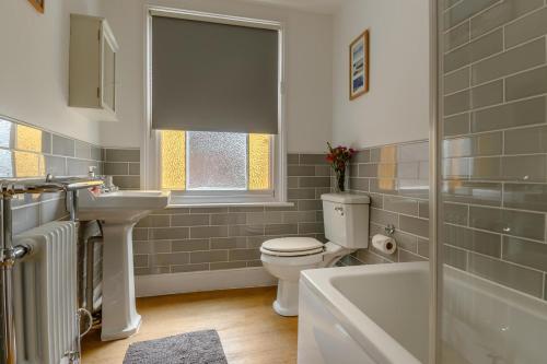 a bathroom with a toilet and a sink and a tub at 2 Bed in Southwold oc-hdoubl in Southwold