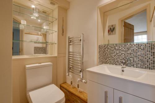 a bathroom with a toilet and a sink and a mirror at 4 Bed in Wrentham oc-hdress in Wrentham