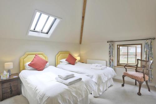 a bedroom with two beds and a chair and a window at 2 Bed in Yoxford oc-hharro in Yoxford