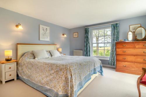 a bedroom with a bed and a dresser and a window at 3 Bed in Bungay oc-taf in Bungay