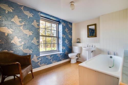 a bathroom with a sink and a toilet and a window at 3 Bed in Bungay oc-taf in Bungay
