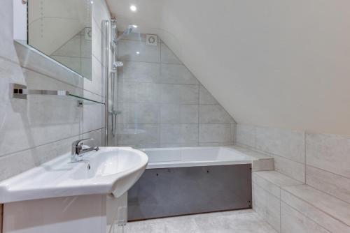 a bathroom with a sink and a bath tub at 1 Bed in Rhodes Minnis oc-ct041 in Lyminge