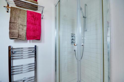 1 Bed in Acle oc-1256 في Cantley: حمام مزود بدُش ومنشفة حمراء
