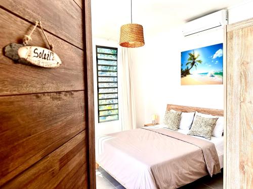 a bedroom with a bed and a wooden wall at Residence Azelina in Pointe aux Canonniers