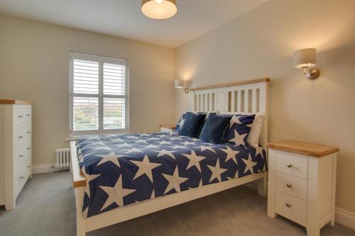 a bedroom with a bed with a blue and white comforter at 2 Bed in Holt oc-2148 in Holt