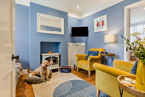 a blue living room with a dog sitting on the floor at 3 Bed in Cromer oc-2077 in Cromer