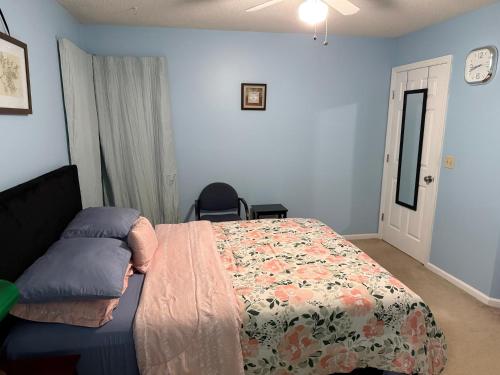 a bedroom with a bed with a floral comforter at Serenity in Statesboro