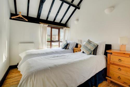 a bedroom with two white beds and a window at 3 Bed in Bacton oc-711 in Bacton