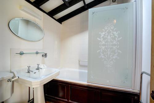 a white bathroom with a sink and a mirror at 3 Bed in Bacton oc-711 in Bacton